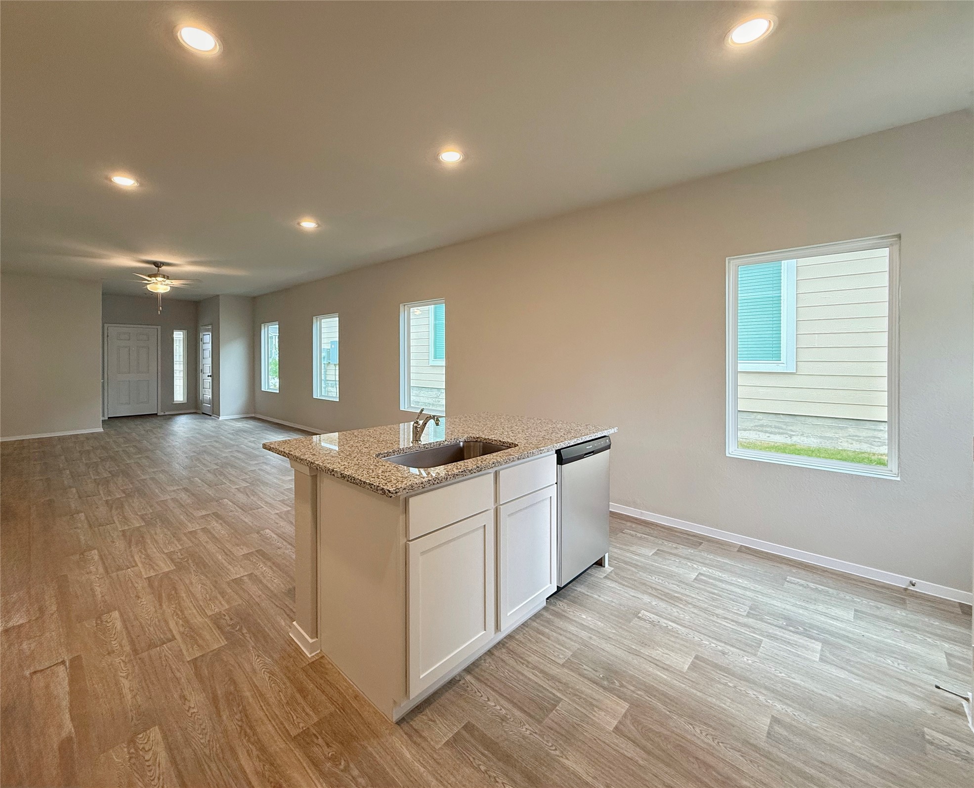 2714 Towy Road Manor, TX 78653 - Photo 22 of 22 An inviting open floorplan featuring a kitchen island and wood-look flooring throughout.