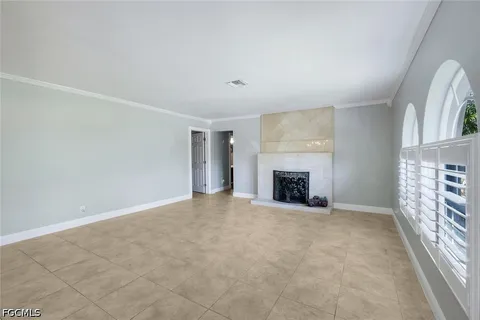 an empty room with windows and fireplace