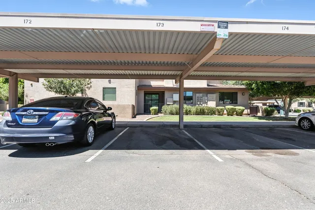 a front view of a house with a garden and a tree