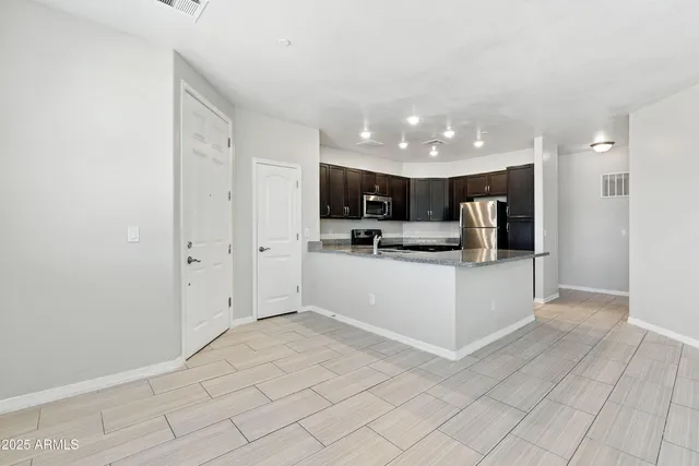 a view of kitchen with refrigerator cabinets and microwave
