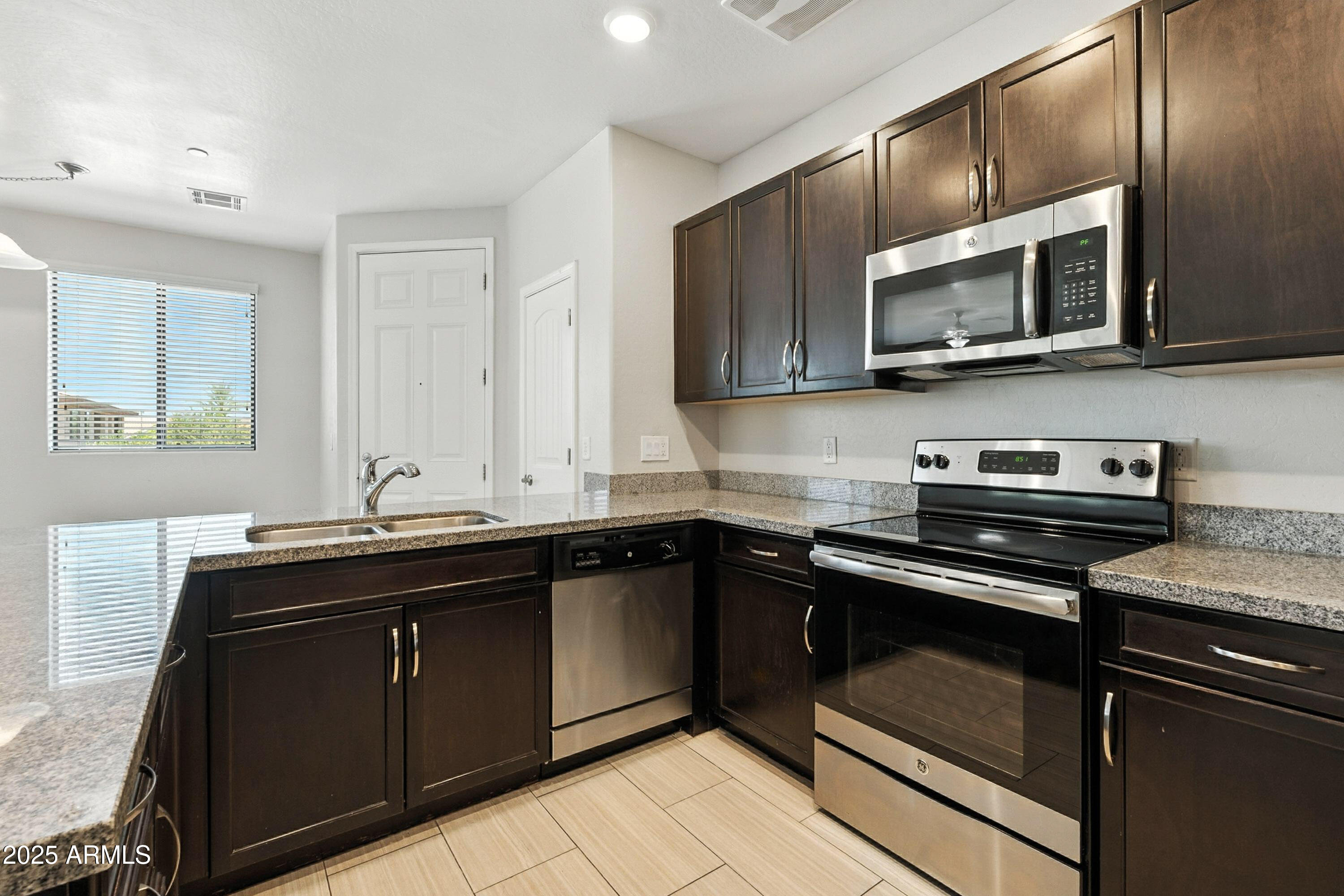 3330 South Gilbert Road, Unit 2066 Chandler, AZ 85286 - Photo 9 of 67 a kitchen with stainless steel appliances a sink stove and microwave