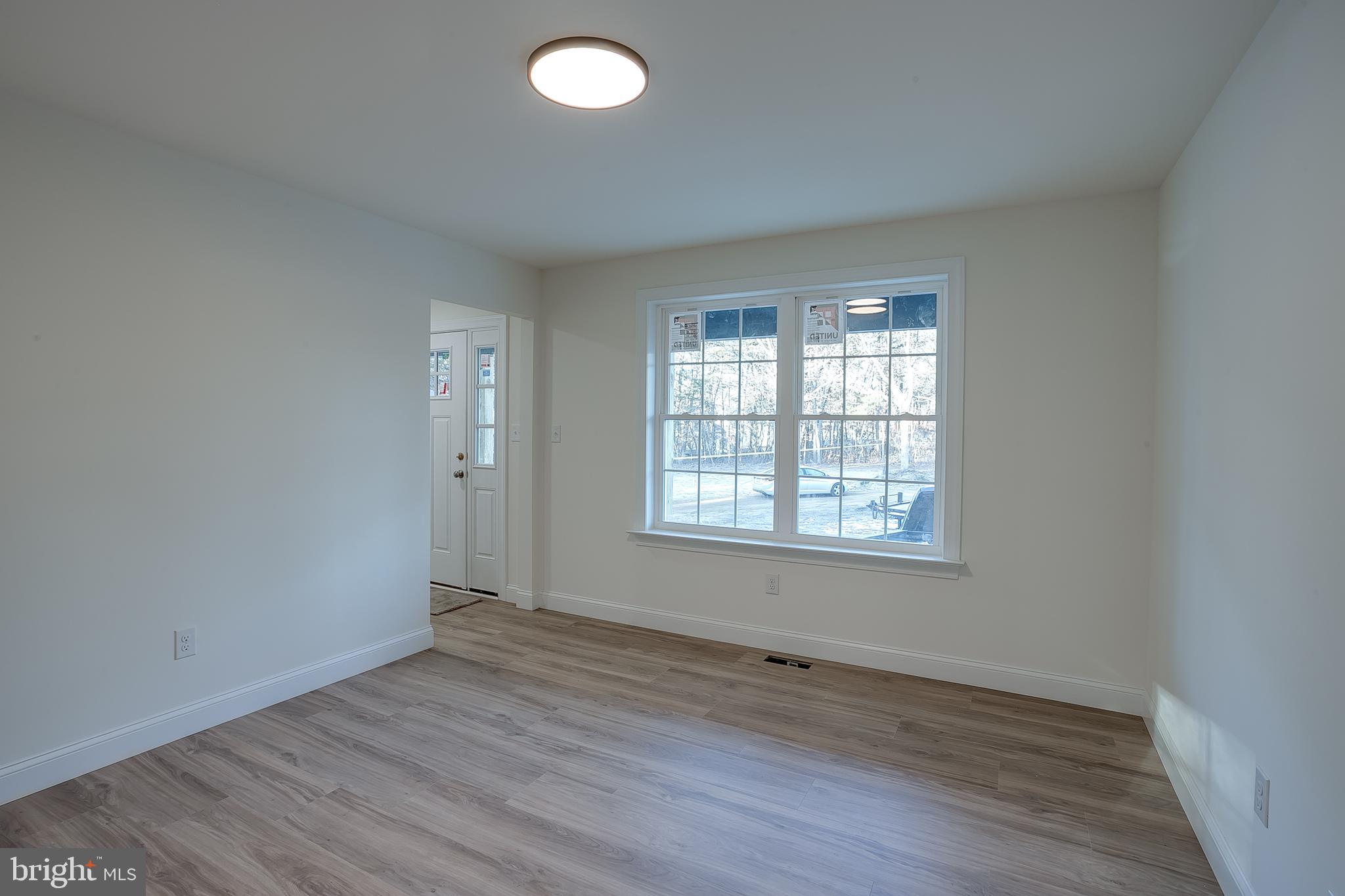 1427 Williamstown Erial Road Sicklerville, NJ 08081 - Photo 6 of 27 an empty room with wooden floor and windows
