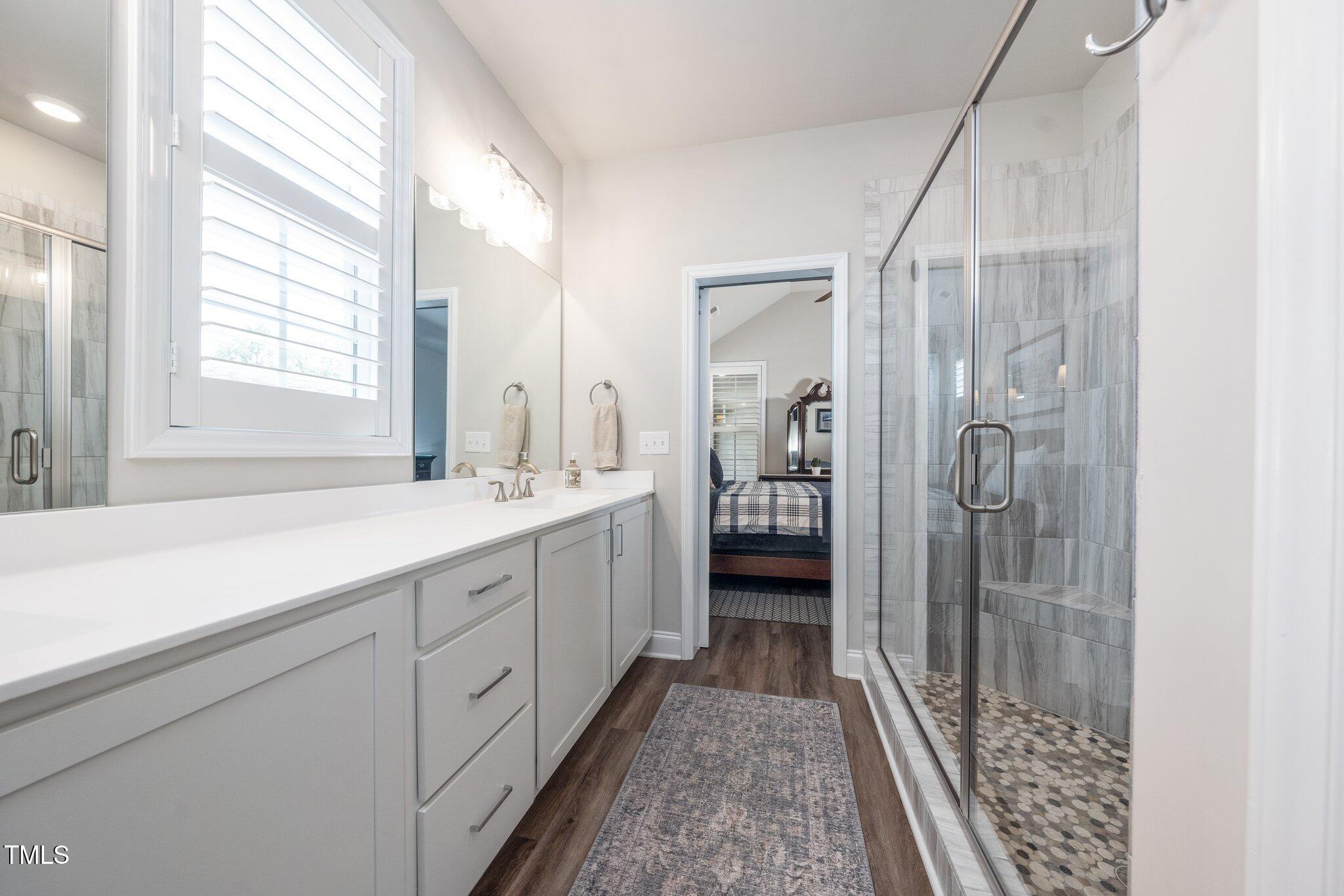 1705 Main Divide Drive Wake Forest, NC 27587 - Photo 20 of 47 a bathroom with a double vanity sink a mirror and a shower