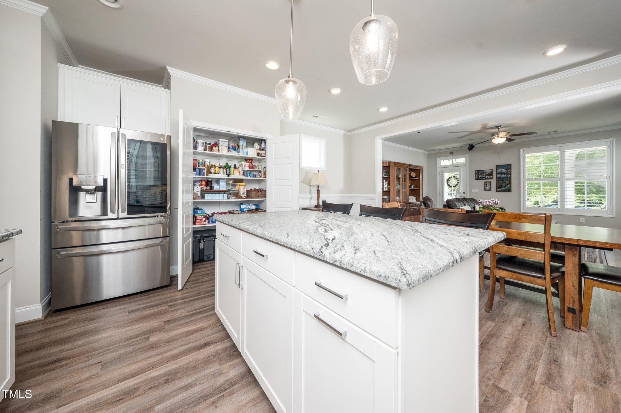 1705 Main Divide Drive Wake Forest, NC 27587 - Photo 7 of 47 a kitchen with stainless steel appliances granite countertop a refrigerator a stove and a wooden floors