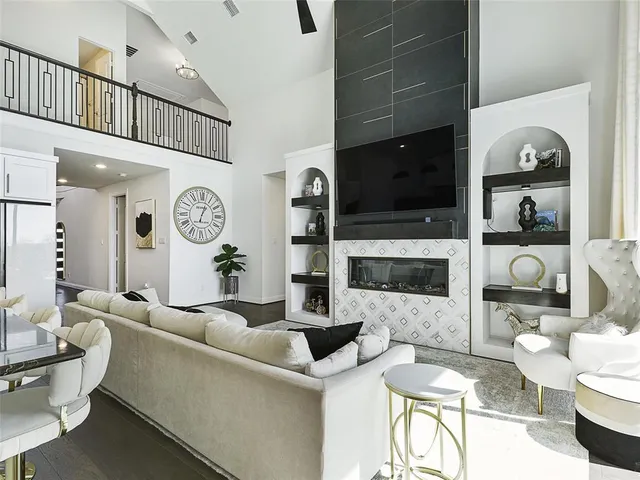 a living room with furniture a flat screen tv and a fireplace