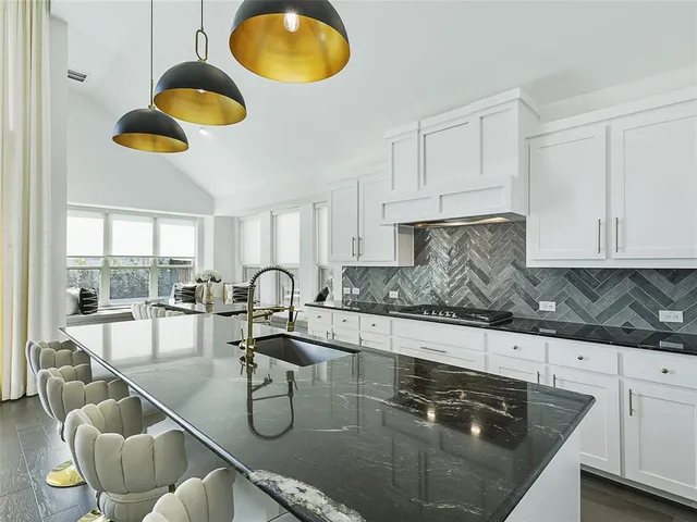 a large kitchen with a large window and stainless steel appliances