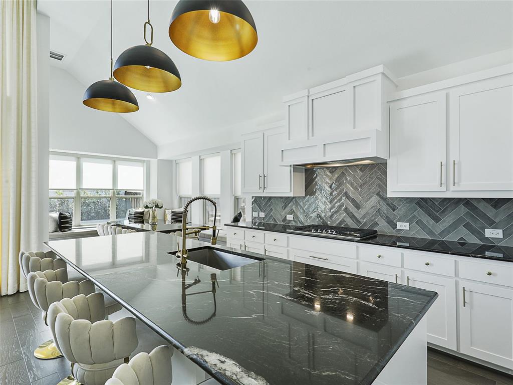 3141 Sunfish Street Prosper, TX 75078 - Photo 15 of 33 a kitchen with stainless steel appliances granite countertop a sink a stove and white cabinets with wooden floor