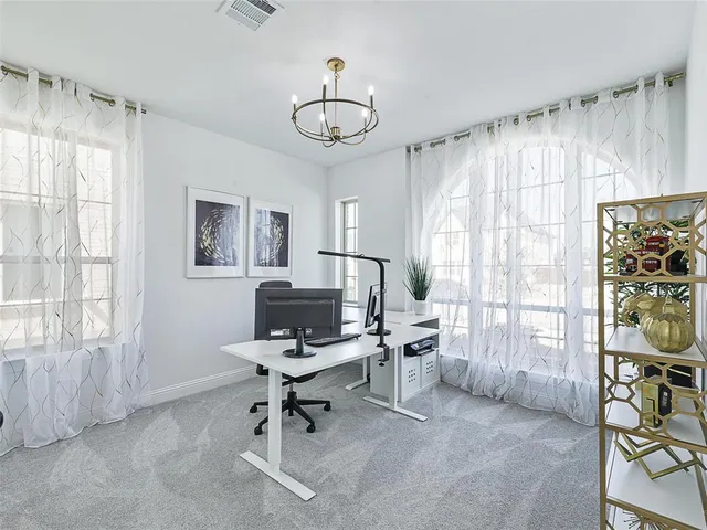 a view of a livingroom with workspace and a window