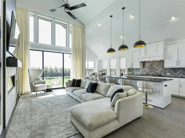 a living room with furniture fireplace and a large window