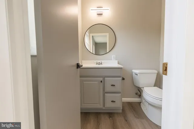 a bathroom with a toilet a sink and a mirror