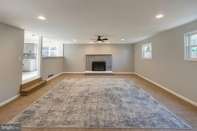 an empty room with windows and fireplace