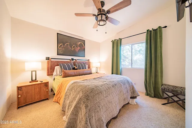 a bedroom with bed and large windows