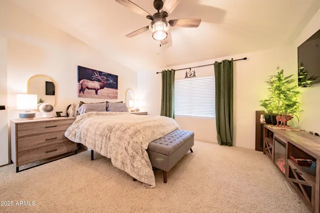 a spacious bedroom with a bed and a flat screen tv