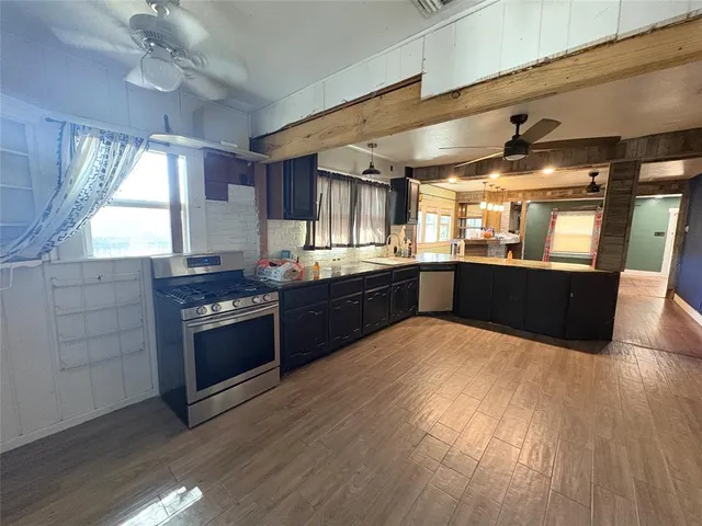 a kitchen with stainless steel appliances granite countertop a sink and wooden cabinets