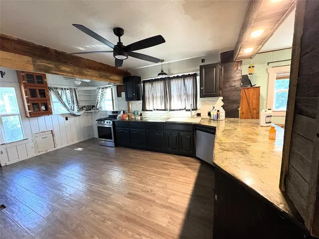 a kitchen with stainless steel appliances kitchen island granite countertop a stove and a sink