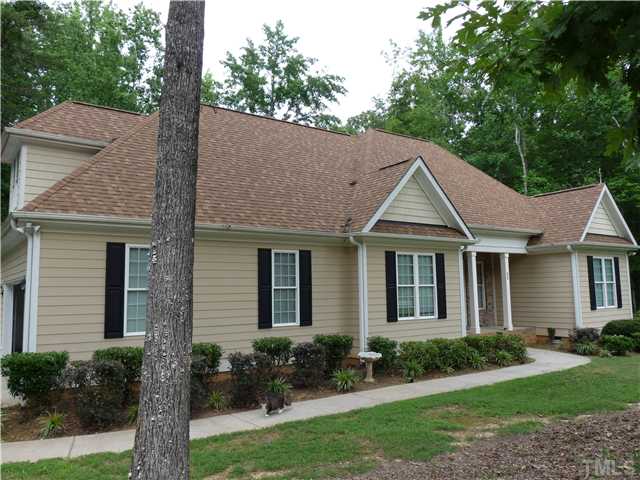 220 Weaver Ridge Road Rougemont, NC 27572 - Photo 12 of 12 a view of a house with a yard plants and large tree