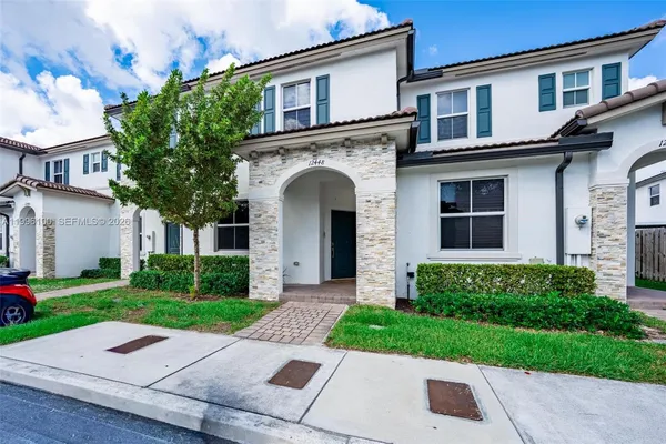 a front view of a house with a garden