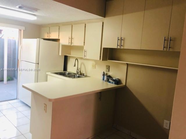 2212 West 74th Street, Unit 10128 Hialeah, FL 33016 - Photo 3 of 12 a kitchen with a sink a refrigerator and a stove
