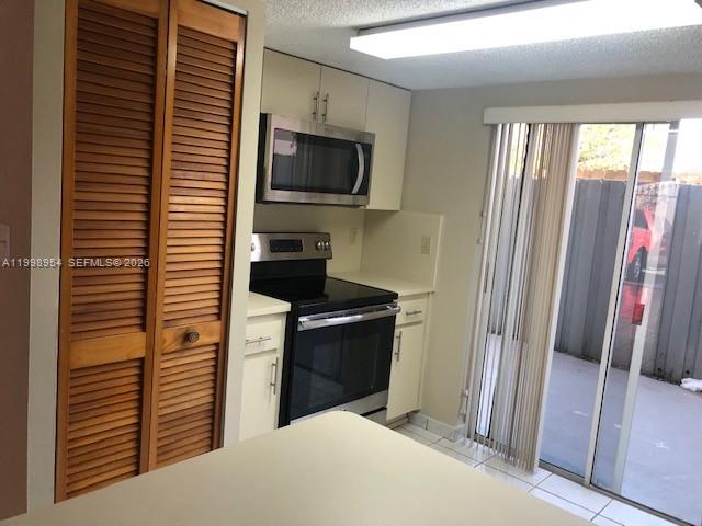 2212 West 74th Street, Unit 10128 Hialeah, FL 33016 - Photo 4 of 12 a kitchen with a refrigerator and a stove top oven