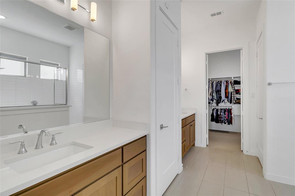 1241 Lupine Road Prosper, TX 75078 - Photo 21 of 38 Spacious bathroom featuring a dual vanity with wood-finish cabinetry and light-toned countertops
