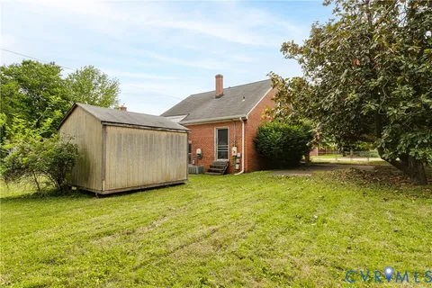 a view of a house with backyard and tree