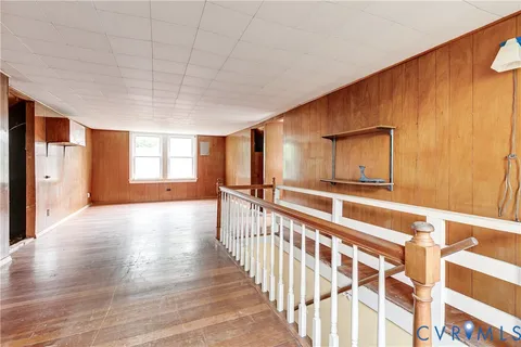 a view of a hallway with wooden floor and windows