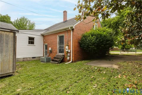 a view of a house with backyard and a tree