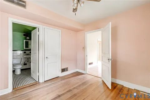 a view of a room with wooden floor and a bathroom