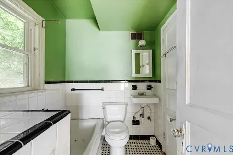 a bathroom with a granite countertop toilet sink and mirror