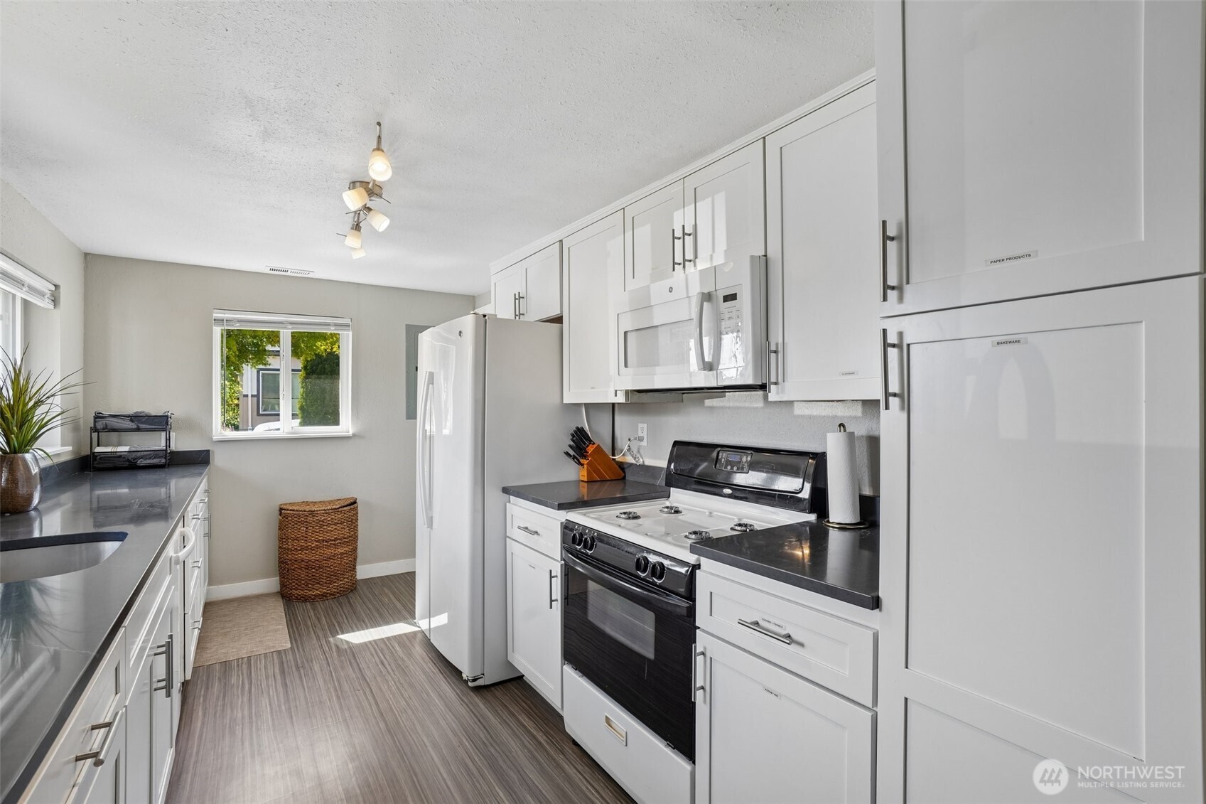 9810 Northeast 3rd Street Vancouver, WA 98664 - Photo 21 of 40 a kitchen with stainless steel appliances white cabinets and wooden floors