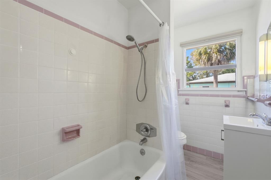 231 North Ridgewood Avenue Ormond Beach, FL 32174 - Photo 21 of 52 a bathroom with a tub a window and a shower