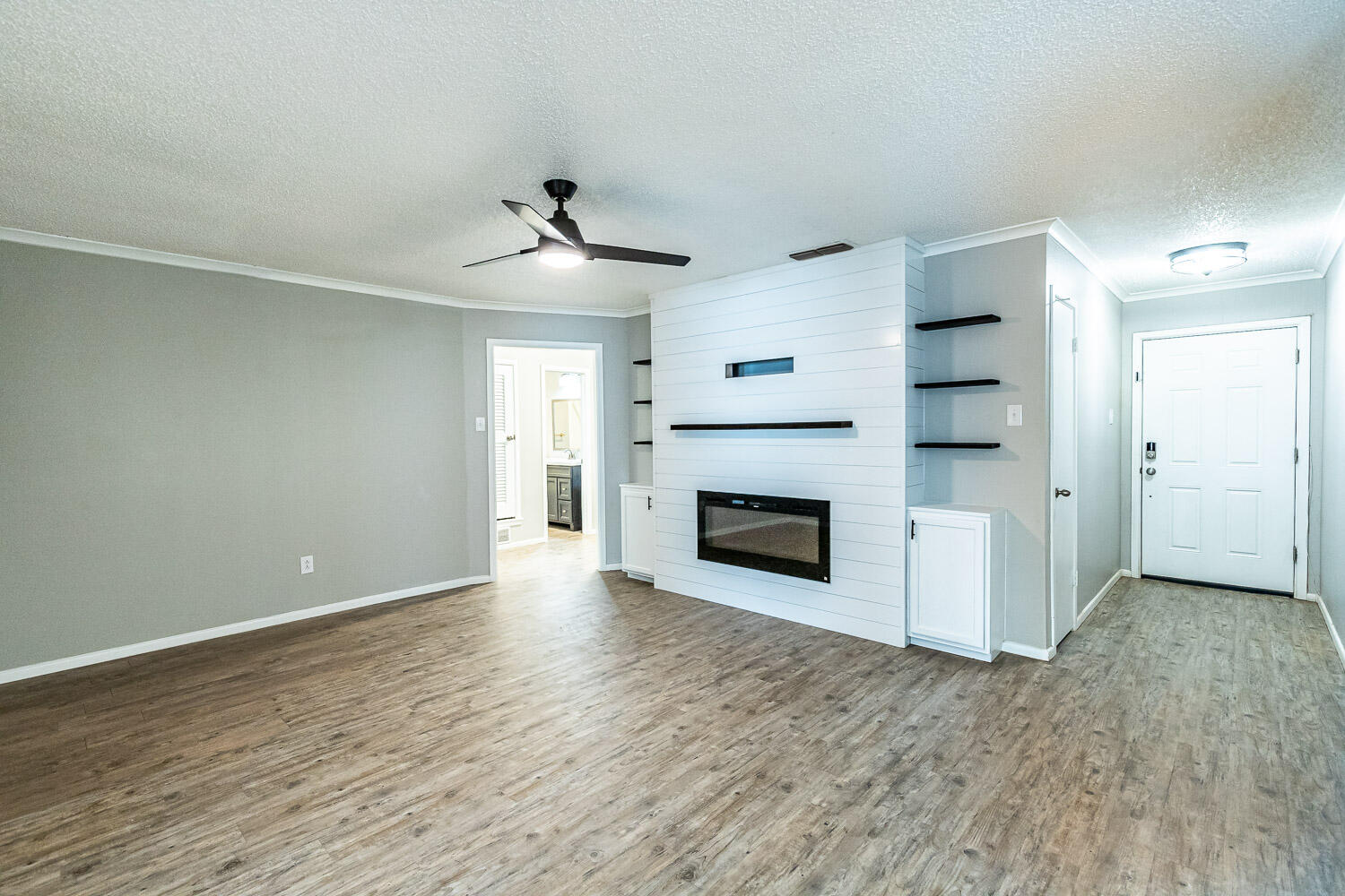 9611 Bangor Avenue Lubbock, TX 79424 - Photo 5 of 29 an empty room with a fireplace and wooden floor