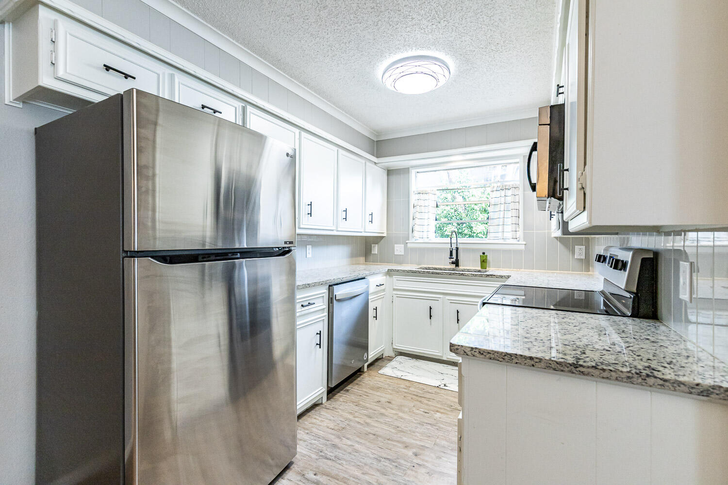 9611 Bangor Avenue Lubbock, TX 79424 - Photo 7 of 29 a kitchen with granite countertop stainless steel appliances a refrigerator sink and microwave