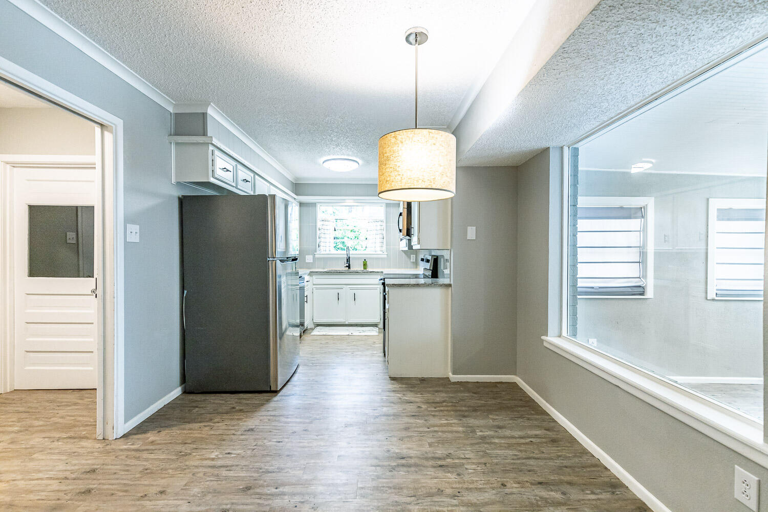 9611 Bangor Avenue Lubbock, TX 79424 - Photo 9 of 29 a view of a kitchen with a refrigerator ceiling fan and wooden floor