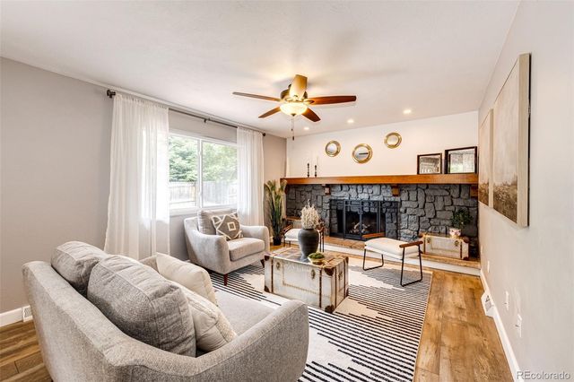 a living room with furniture a fireplace and a large window