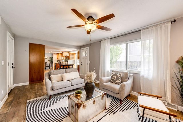 a living room with furniture ceiling fan and a window