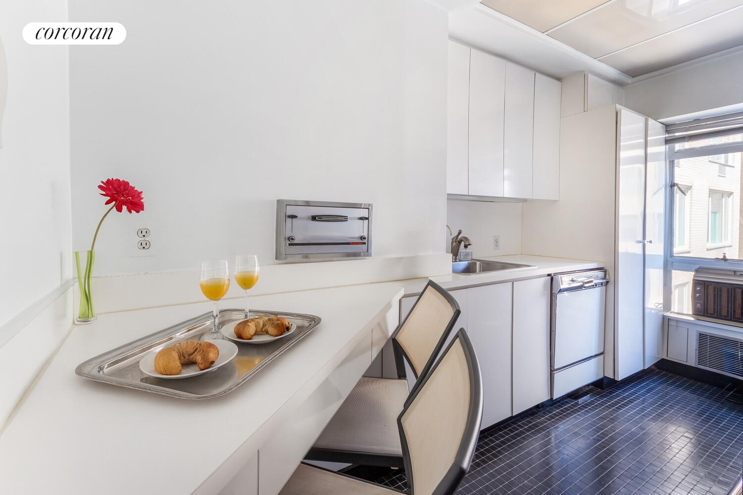 1050 5th Avenue, Unit 11/12A Manhattan, NY 10028 - Photo 4 of 13 a kitchen with sink a stove and white cabinets