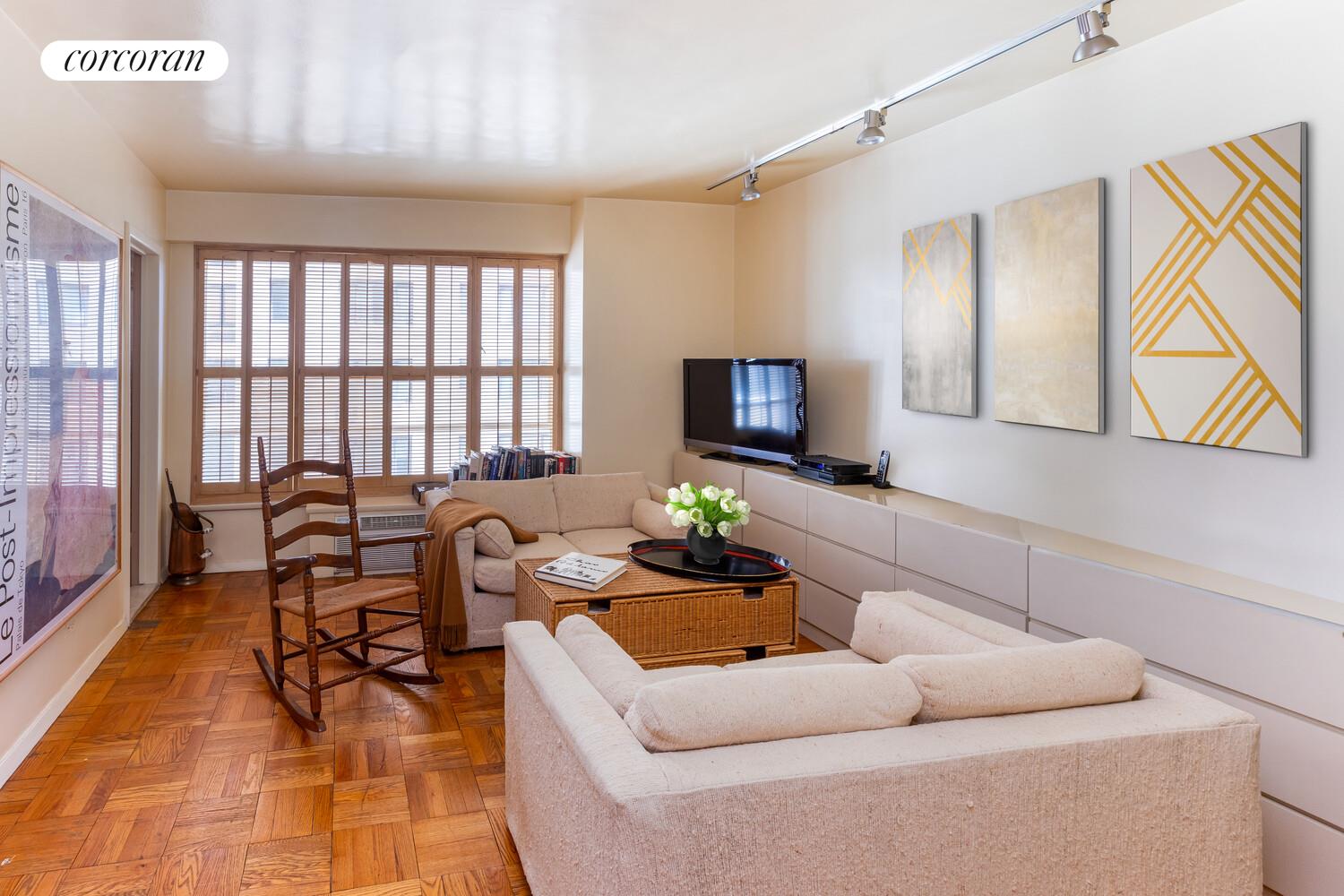 1050 5th Avenue, Unit 11/12A Manhattan, NY 10028 - Photo 7 of 13 a living room with furniture and a potted plant