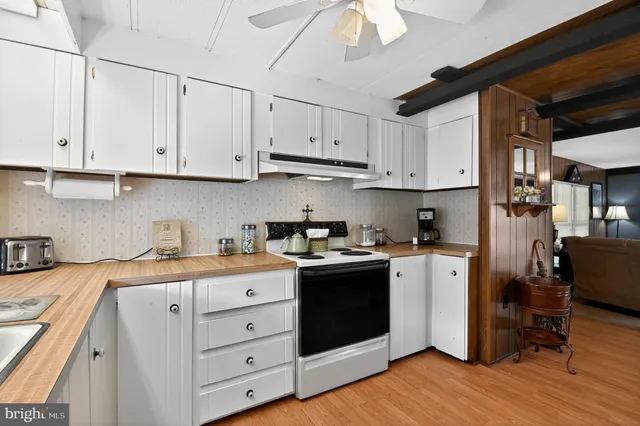 a kitchen with kitchen island granite countertop a sink and a stove