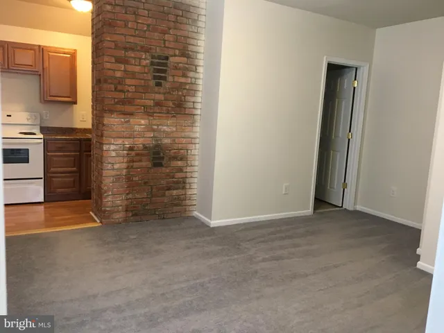 a view of an empty room with brick wall