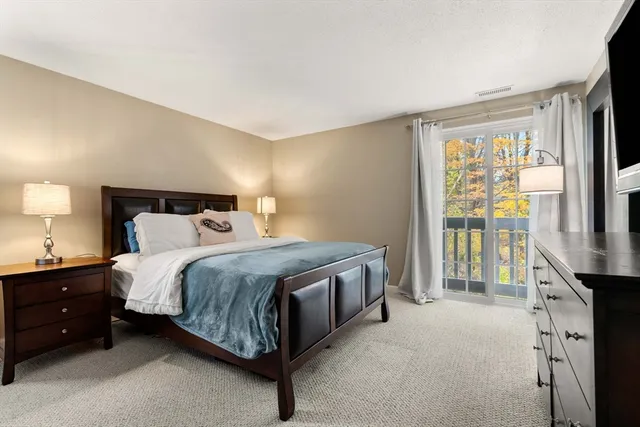 a bed sitting in a spacious bedroom next to a window