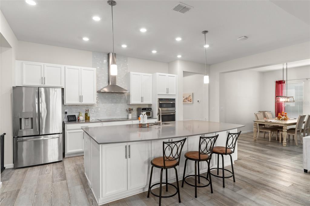 375 Dancing Water Drive Winter Springs, FL 32708 - Photo 11 of 73 a kitchen with stainless steel appliances a dining table chairs stove refrigerator and cabinets