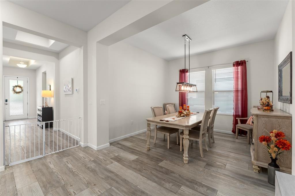 375 Dancing Water Drive Winter Springs, FL 32708 - Photo 13 of 73 a dining room with wooden floor a chandelier a wooden table and chairs