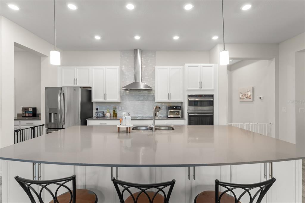 375 Dancing Water Drive Winter Springs, FL 32708 - Photo 9 of 73 a kitchen with stainless steel appliances granite countertop a table chairs microwave and refrigerator