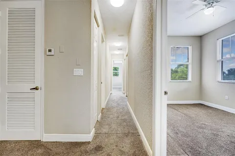 an empty room with windows and fan