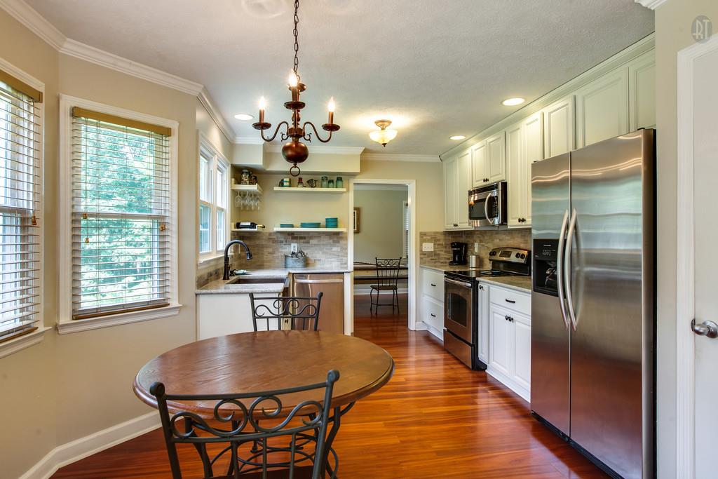 5909 Parham Road Franklin, TN 37064 - Photo 7 of 23 a kitchen with stainless steel appliances granite countertop a refrigerator a sink dishwasher a stove and a dining table with wooden floor