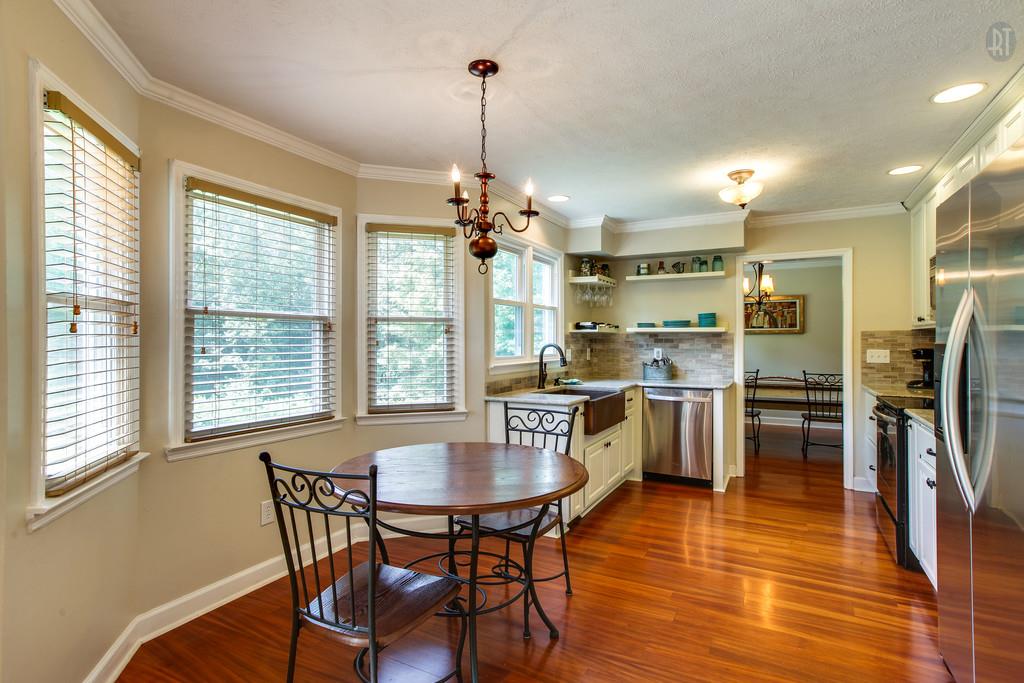 5909 Parham Road Franklin, TN 37064 - Photo 9 of 23 a kitchen with stainless steel appliances a dining table chairs stove and refrigerator