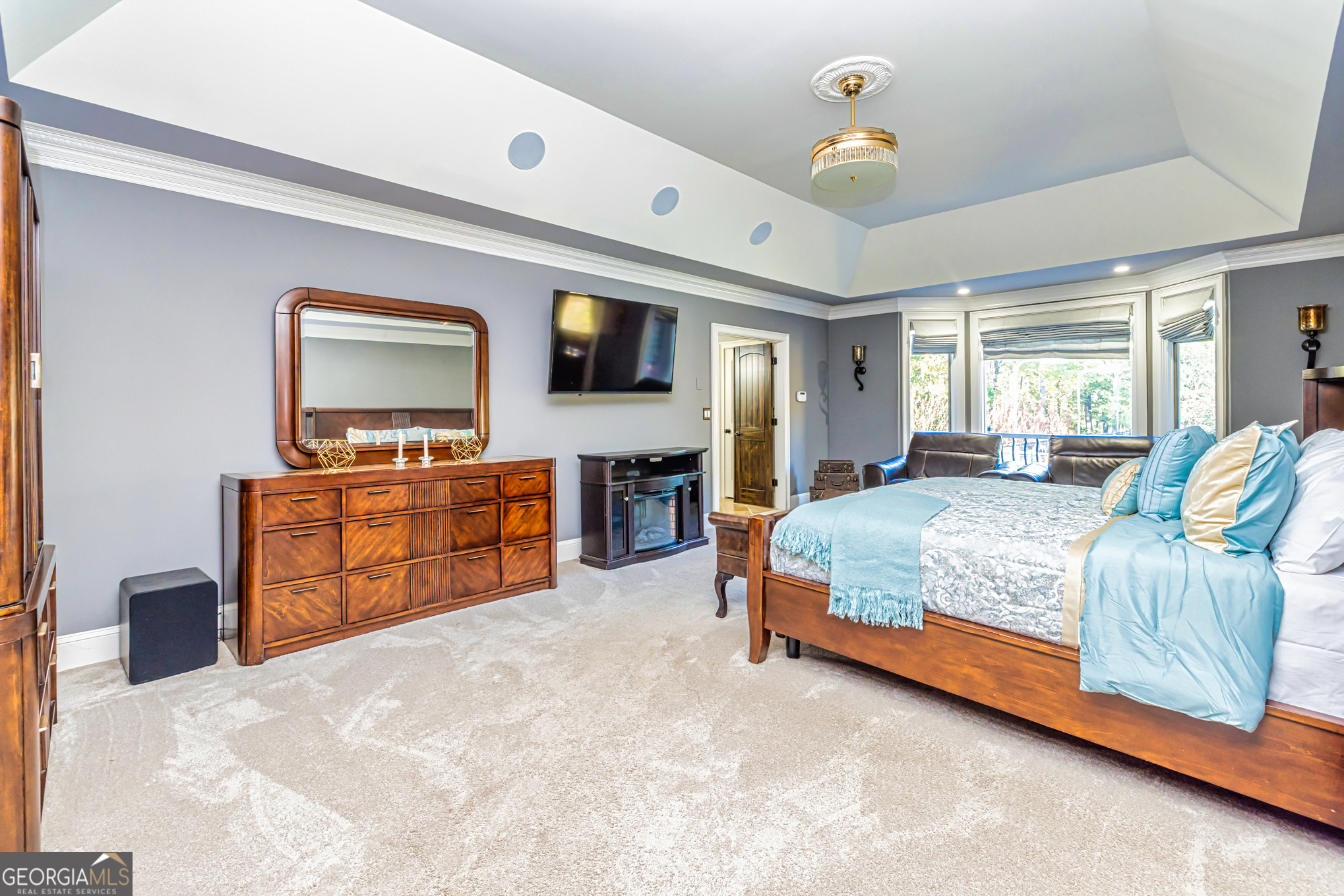 131 Lincoln Road Tyrone, GA 30290 - Photo 32 of 82 a spacious bedroom with a bed and dresser with mirror