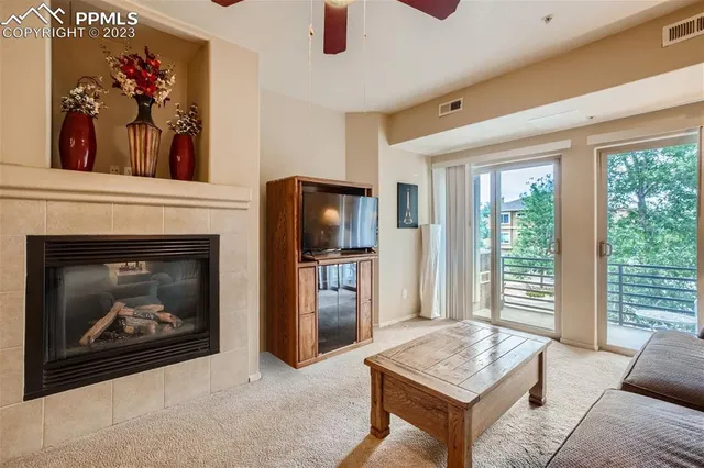 a living room with furniture a flat screen tv and a fireplace