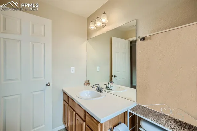 a bathroom with a sink a light fixture and a mirror